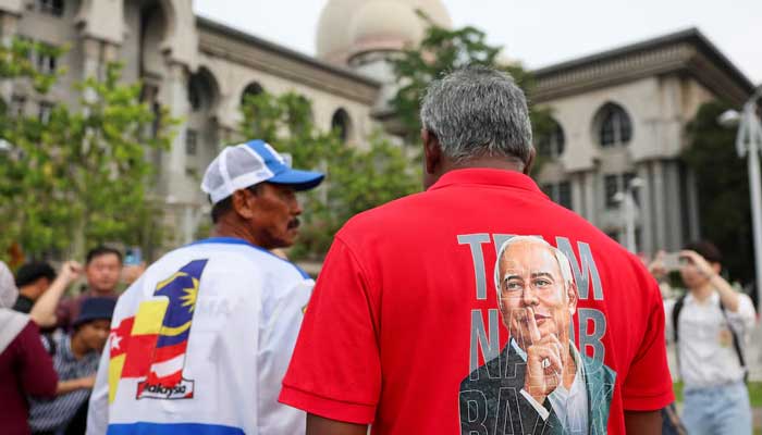 A supporter wears a shirt with former Malaysian PM Najib Razaks potrait printed on it, outside the Palace of Justice in Putrajaya, Malaysia on December 26, 2025. — Reuters