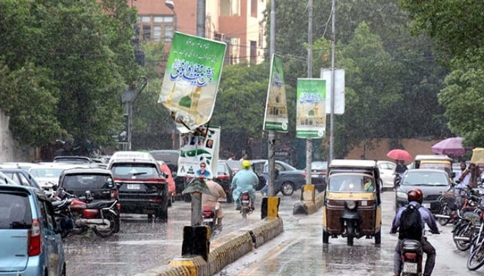 Commuters are passing through a road during the downpour of monsoon season at Saddar area in Karachi. — PPI/File