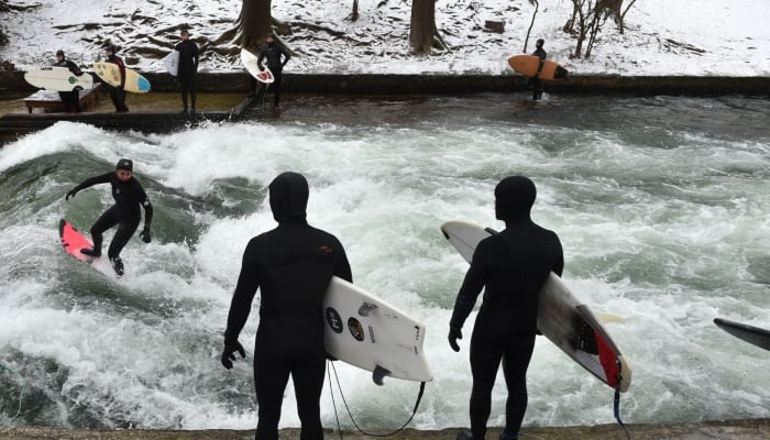 A surfer rides an artificial wave in the canal of the Eisbach river at the English Garden park in Munich, southern Germany. — AFP/File