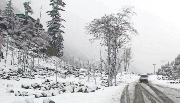 A representational image of a road, hills and trees covered in snow in the northern areas of Pakistan. — APP