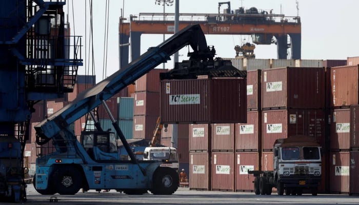 A mobile crane carries a container at Deendayal Port in Kandla, in the western state of Gujarat, India, April 5, 2025. — Reuters