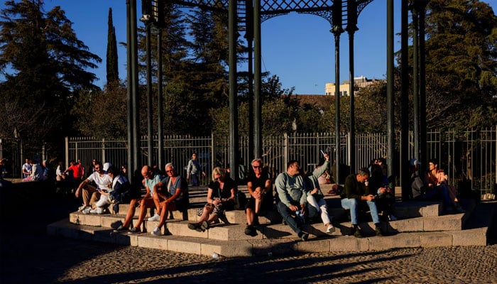 Tourists enjoy the sunset during a sunny and warm spring day with unusually high temperatures, at the Blas Infante lookout in Ronda, Spain, on March 29, 2025. — Reuters