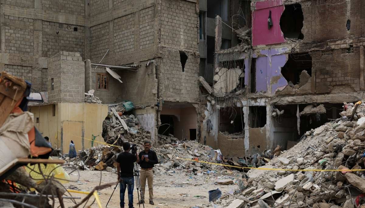 Members of the media report from the ground near a five-storey residential building that collapsed on Friday, July 4, in Karachi on July 7, 2025. — Reuters