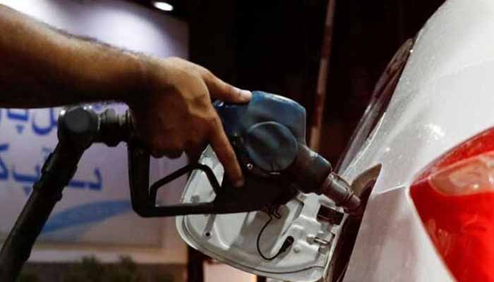 A worker holds a fuel nozzle to fills fuel in a car at a petrol station in Karachi. — Reuters/File