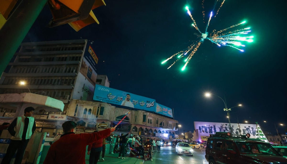 A man launches fireworks during New Year celebrations in Baghdad, early on January 1, 2026. — AFP