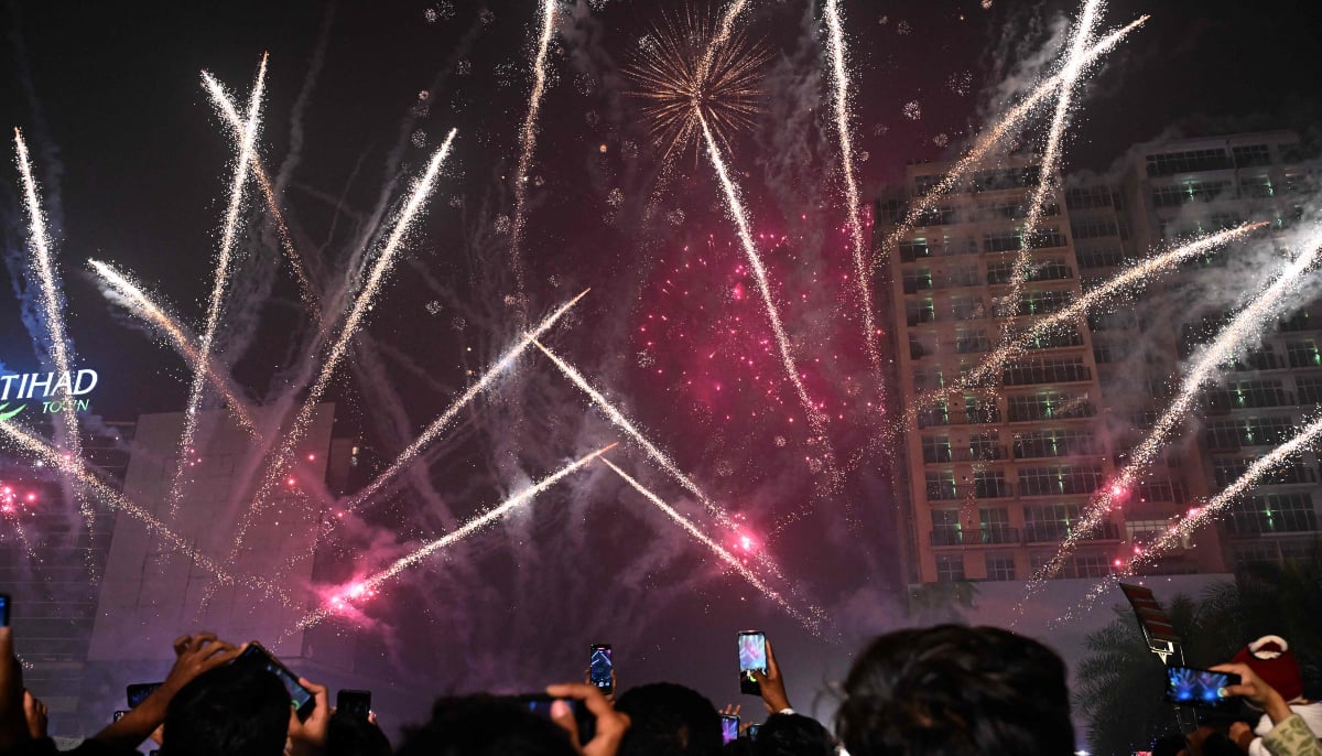 Revellers watch fireworks during the New Year celebrations in Lahore on January 1, 2026.