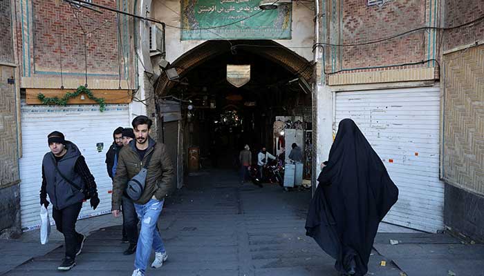 People walk past closed shops following protests over a plunge in the currencys value, in the Tehran Grand Bazaar, Tehran, Iran, December 30, 2025. — Reuters