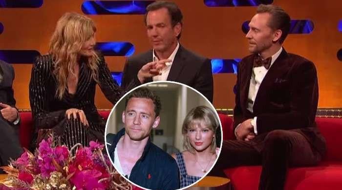 Tom Hiddleston listens to Laura Dern tell a story about his ex Taylor Swift