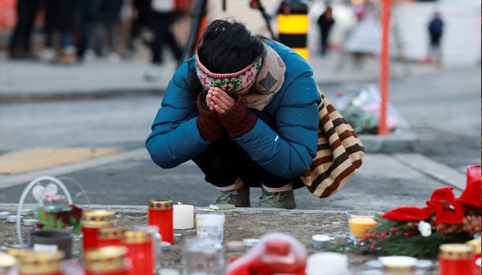 A person pays tribute next to the candles placed for the victims outside the Le Constellation bar, after a fire and explosion during a New Years Eve party where several people died and others were injured, according to Swiss police, in the upscale ski resort of Crans-Montana in southwestern Switzerland, January 2, 2026. — Reuters