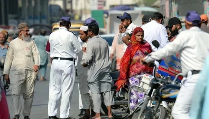Traffic police officials issue a challan for violating the traffic rules in Karachi on April 15, 2025. — PPI