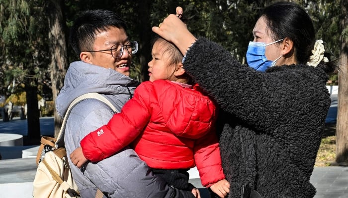 A family is pictured at a park in Beijing on January 3, 2026. — AFP