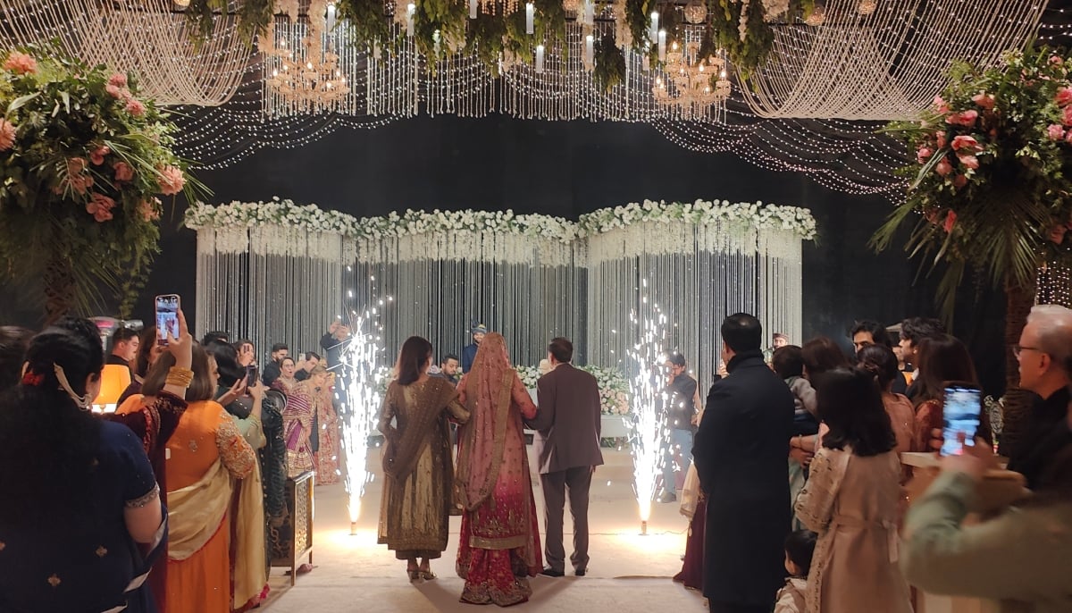 This photograph shows a bride walking towards the groom at the stage. — Photo by author