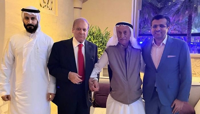 Former prime minister Nawaz Sharif poses with business figures during a meeting in Dubai as part of his UAE visit. — Reporter