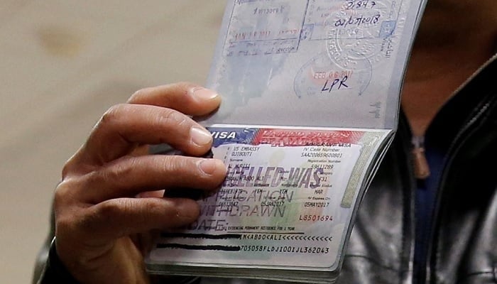 A traveller shows the cancelled visa in his passport to reporters at Washington Dulles International Airport in Chantilly, Virginia, US, February 6, 2017.—Reuters