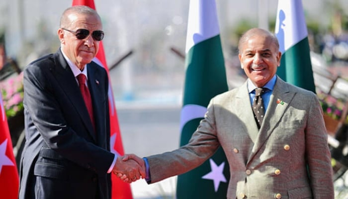 Turkiyes President Recep Tayyip Erdogan (left) shaking hands with Prime Minister Shehbaz Sharif before inspecting a guard of honour during his ceremonial reception at the Prime Minister House, Islamabad, February 13, 2025. — AFP