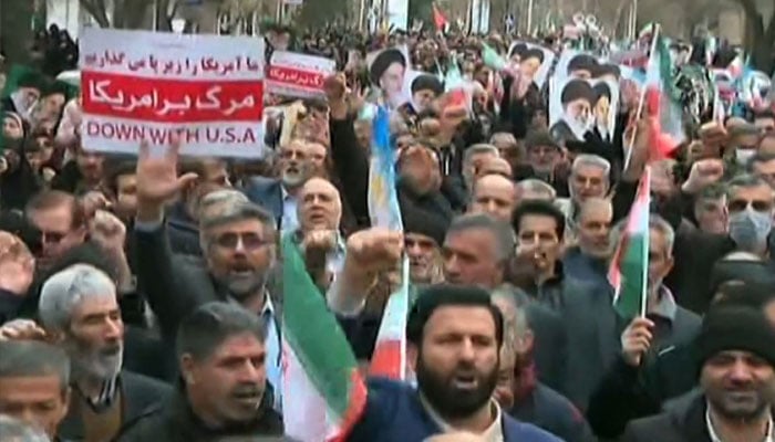 This grab taken from handout video footage released by Iran Press on January 9, 2026, shows pro-government demonstrators chanting slogans as they march along a main street in Khorramabad, western Iran. — AFP