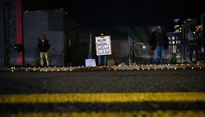 An anti-ICE activist displays a sign during a protest on January 9, 2026 in Portland, Oregon.— AFP