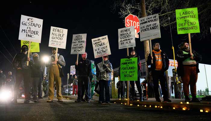 Anti-ICE activists display signs during a protest at the US Immigration and Customs Enforcement facility on January 9, 2026 in Portland, Oregon.— AFP