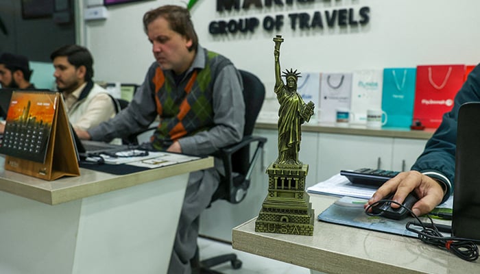 Employees work at a visa consultancy office in Peshawar, January 15, 2026. — Reuters
