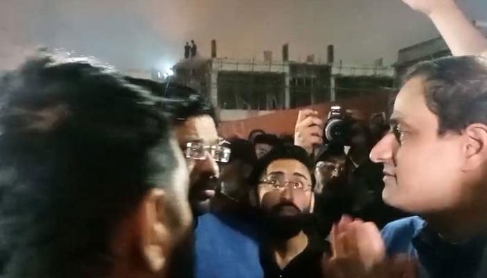 People chanting slogans against Karachi Mayor Murtaza Wahab during his visit to gutted Gul Plaza on January 18, 2026. — Geo News
