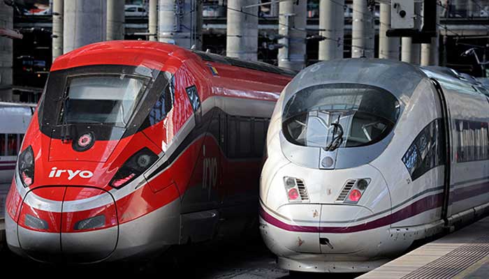High-speed train AVE of the Spanish national railways company RENFE (R) is seen next to high-speed train of private operator Iryo of ILSA company at the Atocha station in Madrid, on February 26, 2023. — AFP