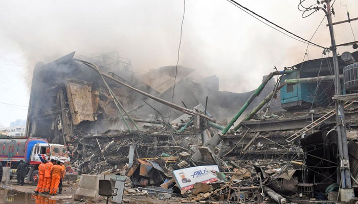 Rescue workers stands outside a collapsed Gul Plaza shopping centre in Karachi on January 18, 2026. — Online