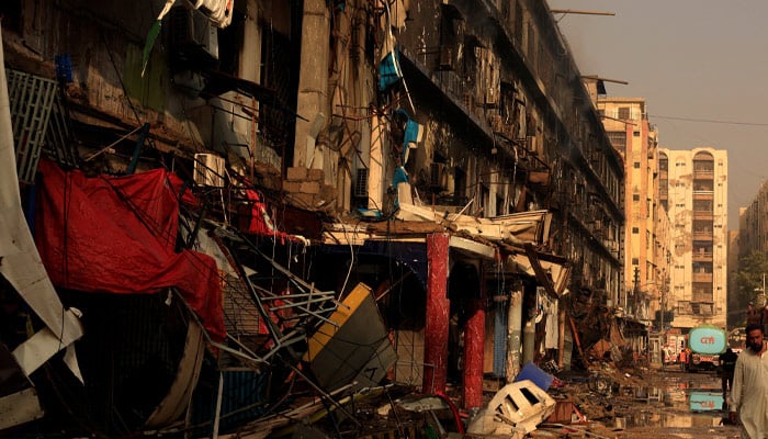 A man moves past debris following a massive fire that broke out in the Gul Plaza Shopping Centre in Karachi, January 19, 2026. — Reuters
