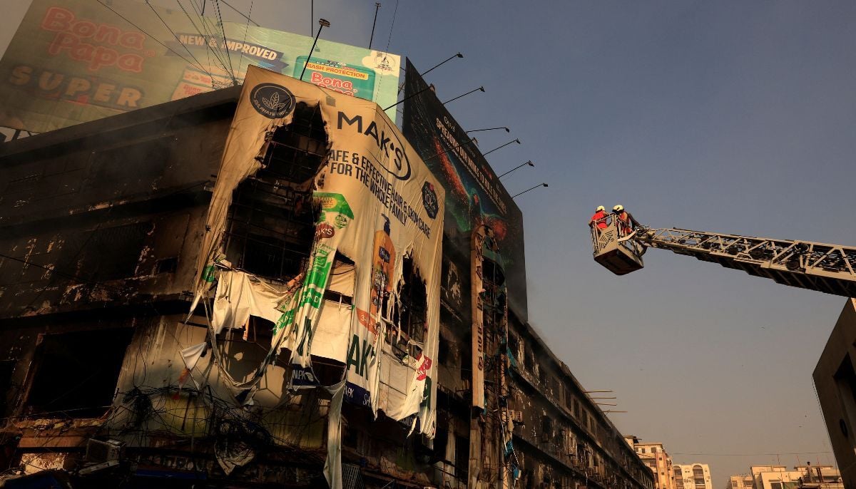 Firefighters work next to smouldering remains following a massive fire that broke out in the Gul Plaza Shopping Centre in Karachi, January 19, 2026. — Reuters