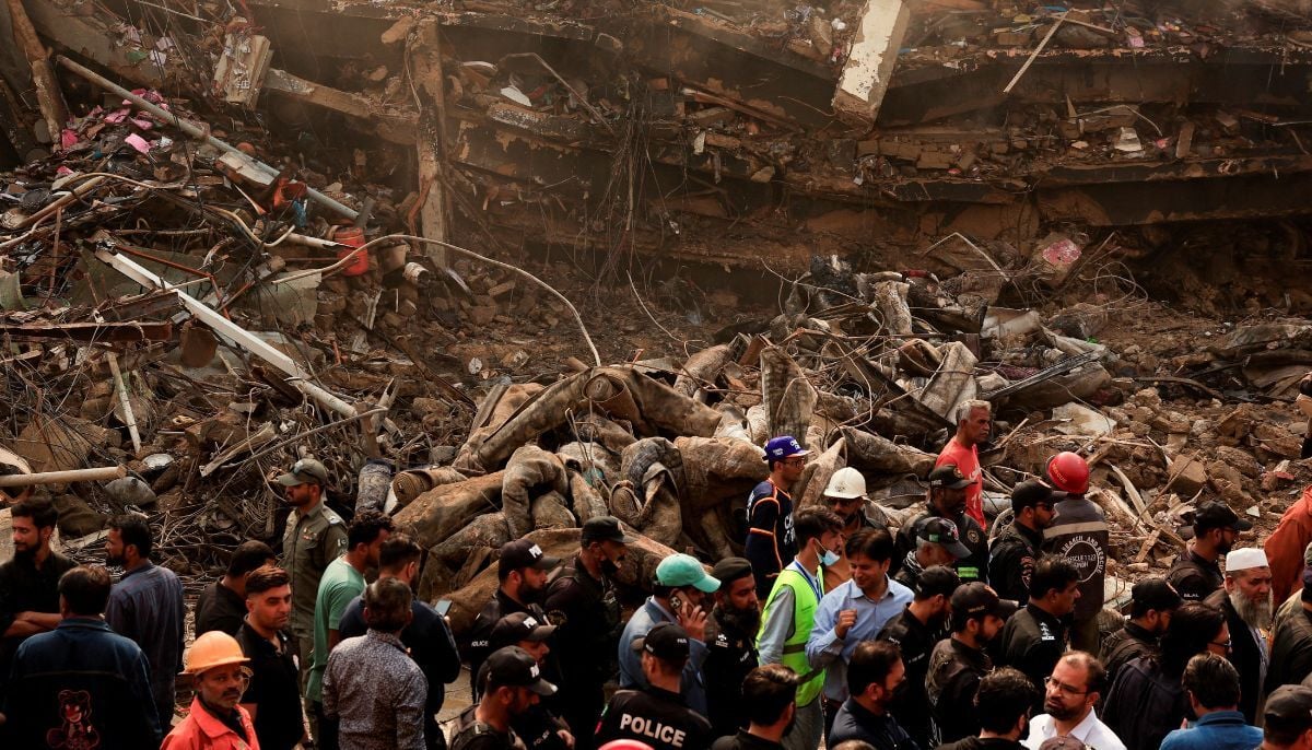 Police officers, rescue workers and shopkeepers gather, following a massive fire that broke out in the Gul Plaza Shopping Mall in Karachi, January 19, 2026. — Reuter