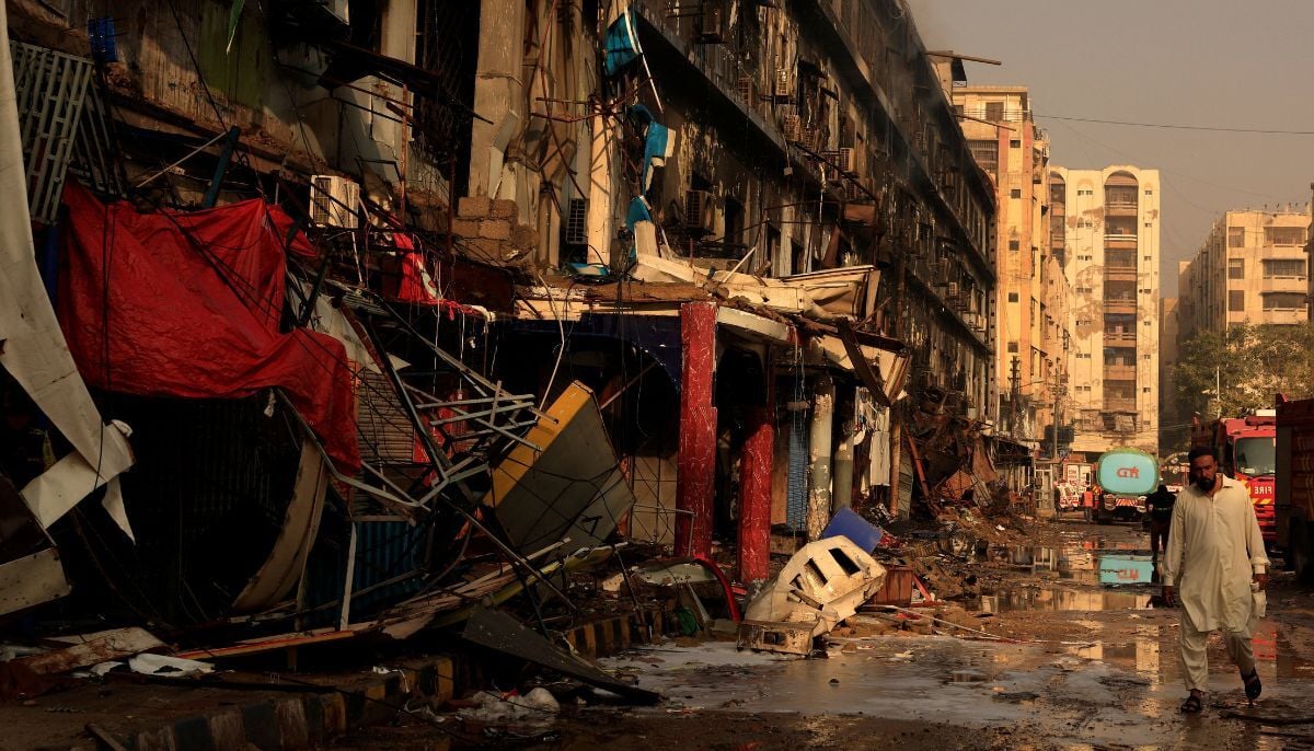 A man moves past debris following a massive fire that broke out in the Gul Plaza Shopping Centre in Karachi, January 19, 2026. — Reuters