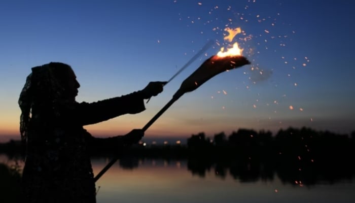 Fortune teller burns a broom during a magical Sanziene ceremony in Bucharest, Romania. — Reuters/File