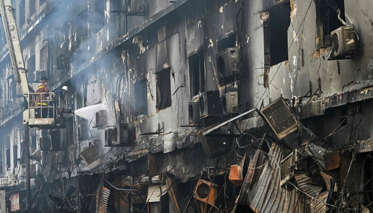 Fire fighters perform a cooling operation on a burnt structure after a massive fire at a shopping mall in Karachi on January 19, 2026. — AFP
