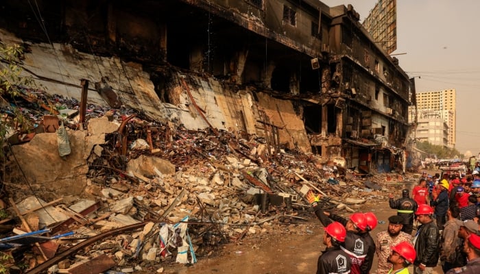 Emergency personnel survey the damaged portion of the building, following a massive fire that broke out in the Gul Plaza in Karachi, January 19, 2026. — Reuters