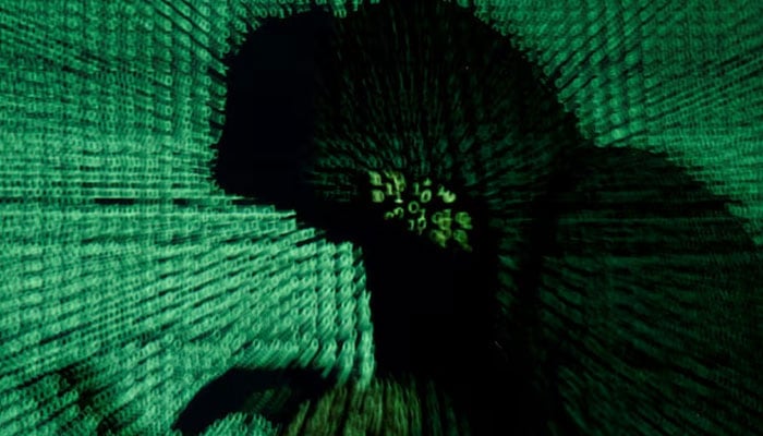 A man holds a laptop computer as cyber code is projected on him in this illustration picture. — Reuters/File