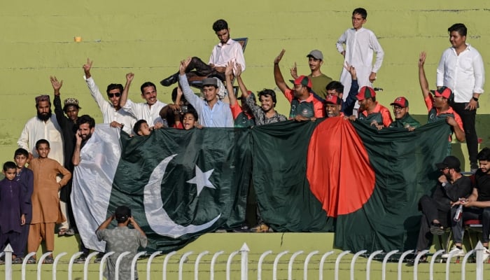 Spectators holding Pakistan’s and Bangladesh’s national flags cheer during a cricket match between the two countries in Rawalpindi on August 21, 2024. — AFP