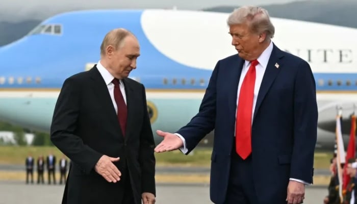 US President Donald Trump, right, reaches out to shake hands with Russian President Vladimir Putin on the tarmac at Joint Base Elmendorf-Richardson in Anchorage, Alaska, on August 15, 2025, before their summit. — AFP