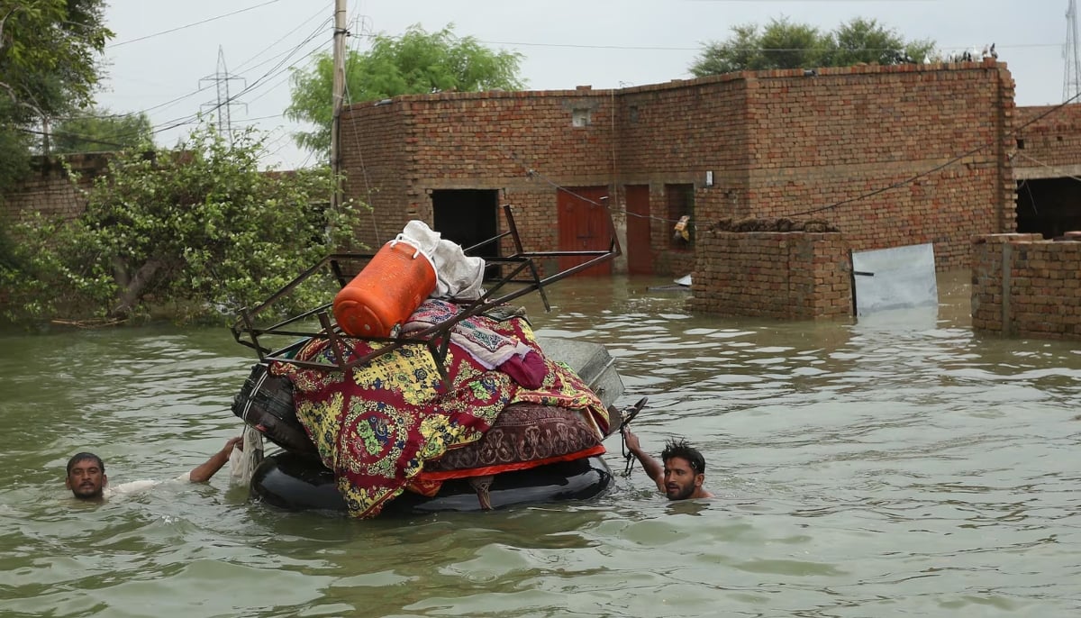 Residents move their belongings from their submerged houses after heavy monsoon rainfall in the Rajanpur, Punjab. — AFP/File