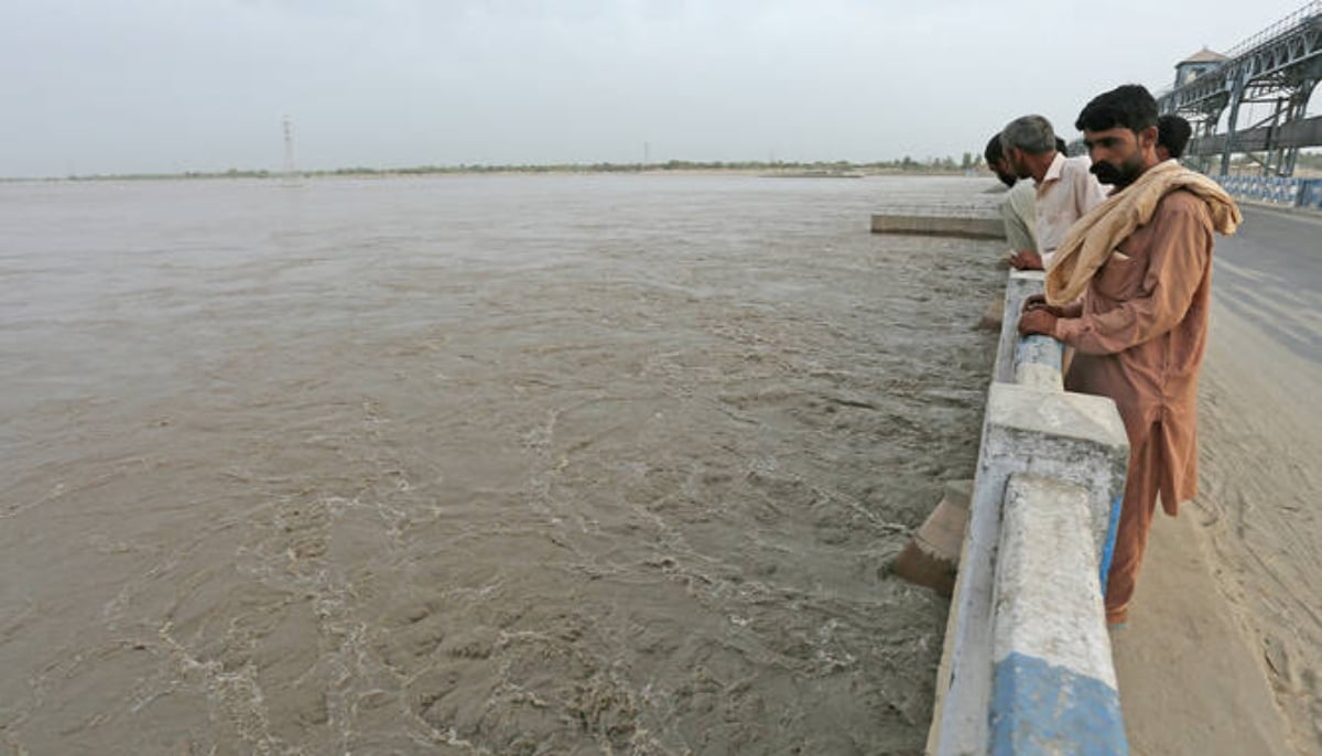 Commuters watch overflowing River Sutlej at Islam Headworks in Hasilpur, Punjab. — AFP/File