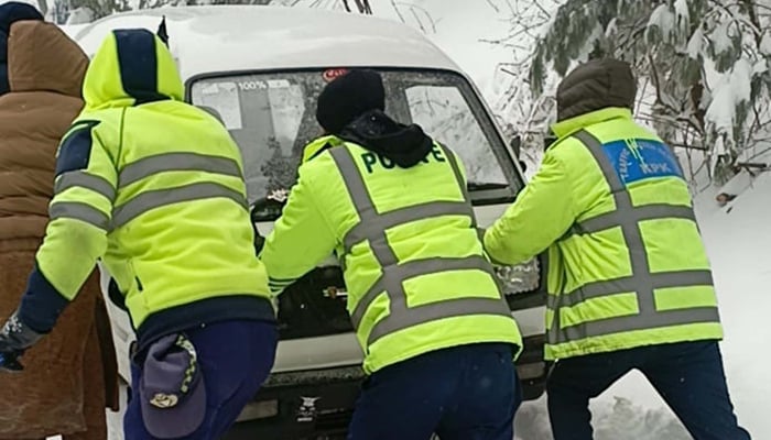 Rescue official trying to remove a vehicle stuck in snow covered area after the heavy snowfall of winter season, which more decreases the temperature below in minus degree Celsius, at Galiyat area in Abbottabad on Friday, January 23, 2026. — PPI