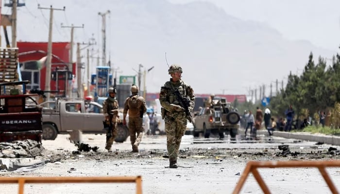 Afghan security forces and a British soldier with Nato-led Resolute Support Mission stand guard at the site of a suicide attack in Kabul, Afghanistan May 31, 2019. — Reuters