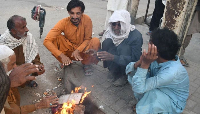 Labourers gather around a fire to warm themselves during a cold winter morning in Karachi on January 7, 2026. — Online