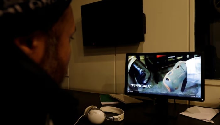 A man looks at a computer screen displaying, what they say is a satire video clip on a social media site, in Islamabad, March 14, 2019. — Reuters