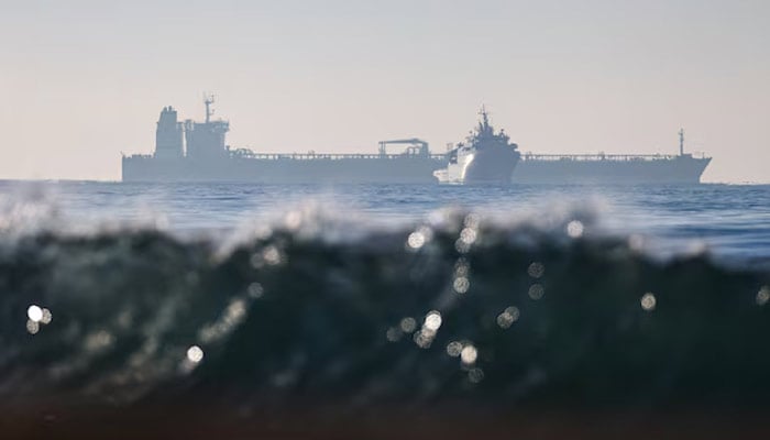 The silhouette of a French navy boat surrounding the GRINCH oil tanker, intercepted by France in the Alboran Sea on suspicion of operating under a false flag and belonging to Russias shadow fleet that enables Russia to export oil despite sanctions, and diverted to the port of Marseille-Fos, in the Gulf of Fos-sur-Mer, near Martigues, France, January 25, 2026. — Reuters