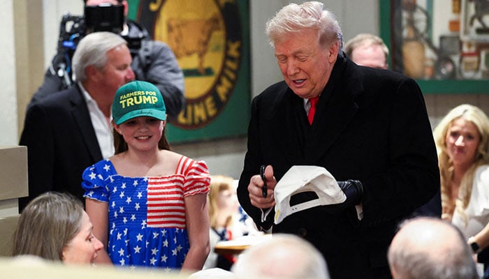 US President Donald Trump signs a cap as he visits Machine Shed restaurant in Urbandale, Iowa, US, January 27, 2026. — Reuters