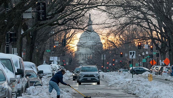 A man shovels snow into the street near the U.S. Capitol as people continue to deal with the aftermath of a major winter storm that dumped snow and ice across a large swath of the United States, in Washington, DC, US., January 27, 2026. — Reuters