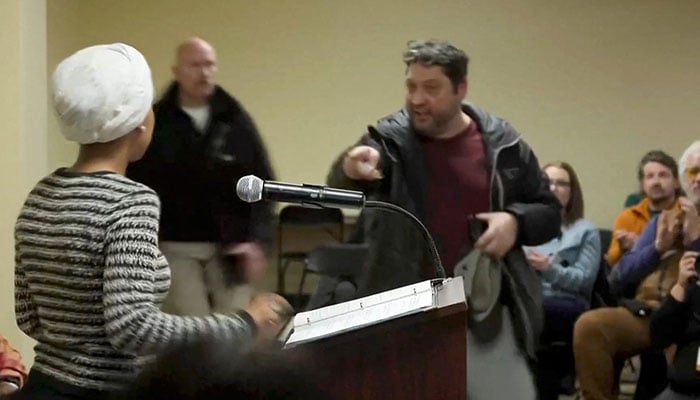 A man shouts at US. Representative Ilhan Omar (D-MN) after spraying her, during a town hall meeting days after a man identified as Alex Pretti was fatally shot by federal immigration agents trying to detain him, in Minneapolis, Minnesota on January 27, 2026. — Reuters