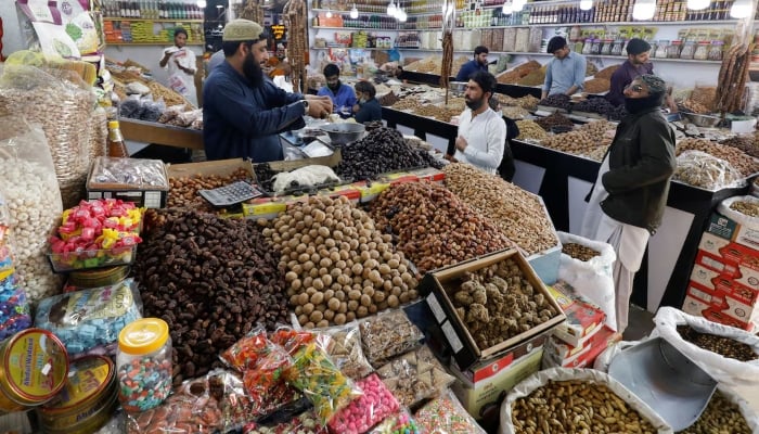 People buy dry fruits at a market in Karachi, Pakistan February 1, 2023. — Reuters
