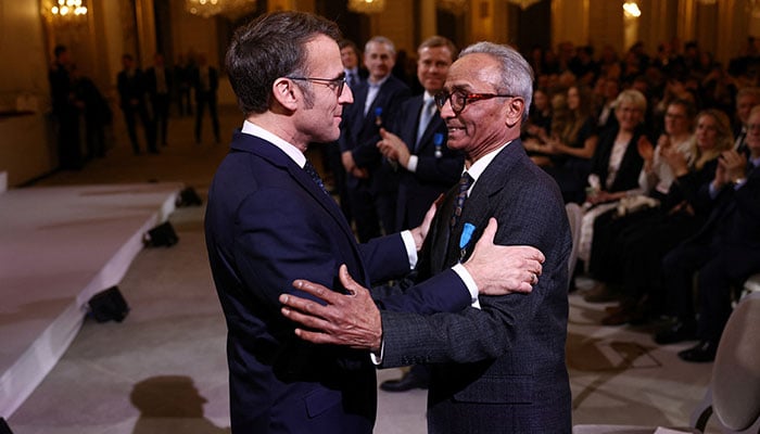 French President Emmanuel Macron gives the Chevalier of the French Order of Merit award to Ali Akbar, who hawks newspapers around the streets of Saint-Germain-des-Pres in the French capital for 50 years, during a ceremony at the Elysee Palace in Paris, France on January 28, 2026. — Reuters