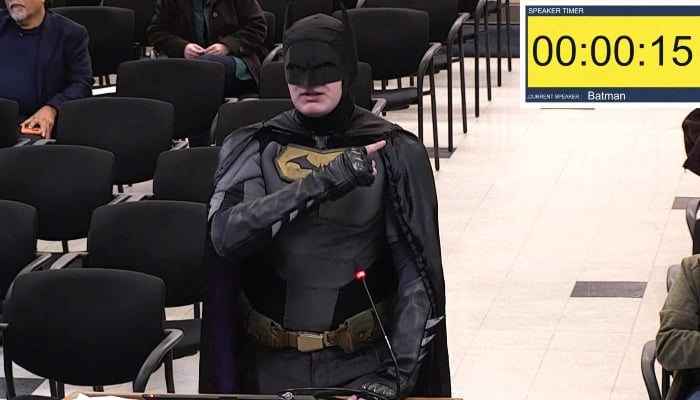 This frame grab from a January 27, 2026, video from a City of Santa Clara, California, city council meeting shows a man dressed as Batman berating officials in the city. — AFP