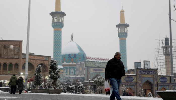 People walk during a snowfall on a street in Tehran, Iran, January 23, 2026. — Reuters